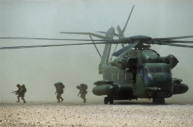 American troops from the Army's 10th Mountain Division from Fort Drum, N.Y., run from a helicopter as they seized the runway in Belet Huen, Somalia, December 28, 1992.  Belet Huen is the last to be secured of eight points designated by the U.N. forces in Somalia as hubs for food distribution. (Photo by J. Scott Applewhite/AP Photo)