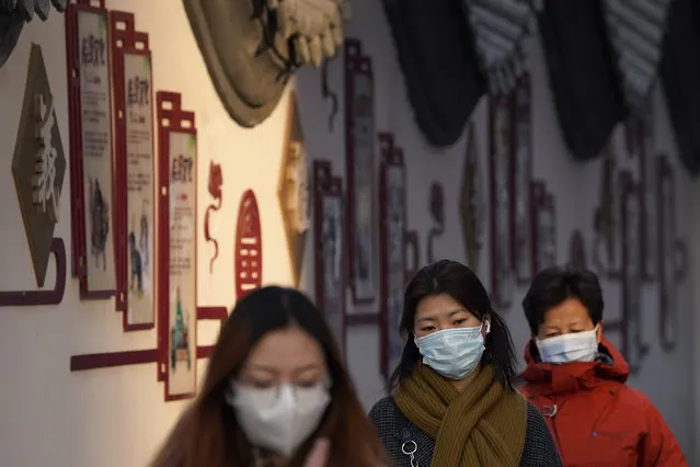 Women wearing face masks to help curb the spread of the coronavirus head for work during the morning rush hour in Beijing, Tuesday, December 1, 2020. (Photo by Andy Wong/AP Photo)