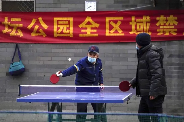 People wearing face masks to help curb the spread of the coronavirus play table tennis in the morning at a public park in Beijing, Wednesday, December 9, 2020. (Photo by Andy Wong/AP Photo)