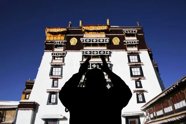 A Tibetan man prays at the Potala Palace in Lhasa, Tibet Autonomous Region, China November 17, 2015. The Potala Palace, once the seat of Tibetan government and traditional residence of Dalai Lama, is a 13-storey palace with more than 1000 rooms. More than 1,300 years old, the palace is more than 3,700 meters above sea level and is a UNESCO World Heritage site. (Photo by Damir Sagolj/Reuters)