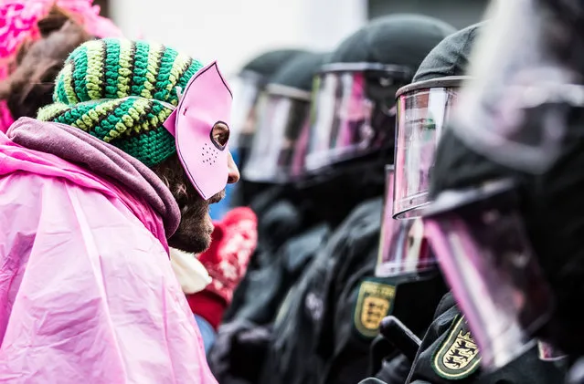 An activist  in pink clothes and a mask clashes with riot police during a demonstration organized to protest against the Federal Congress held by far-right NPD on November 21, 2015 in Weinheim, Germany. (Photo by Simon Hofmann/Getty Images)