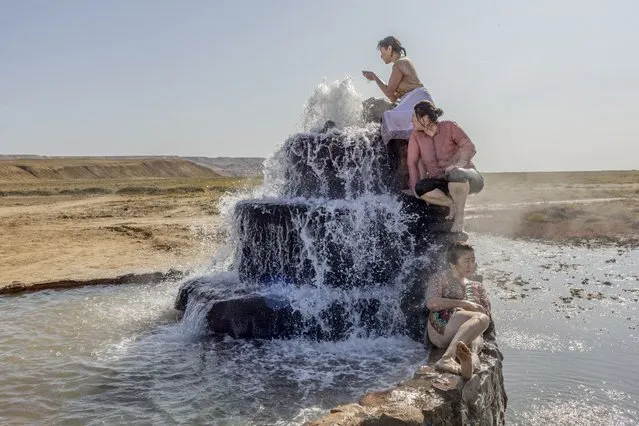 This image provided by World Press Photo is part of a series titled Battered Waters which won the World Press Photo Long Term Projects award by photographer Anush Babajanyan, VII Photo for National Geographic Society, shows Women visit a hot spring that has emerged from the dried bed of the Aral Sea, near Akespe village, Kazakhstan, on 27 August 2019. Once the world's fourth-largest lake, the Aral Sea has lost 90 percent of its content since river water has been diverted. (Photo by Anush Babajanyan, VII Photo for National Geographic Society/World Press Photo via AP Photo)