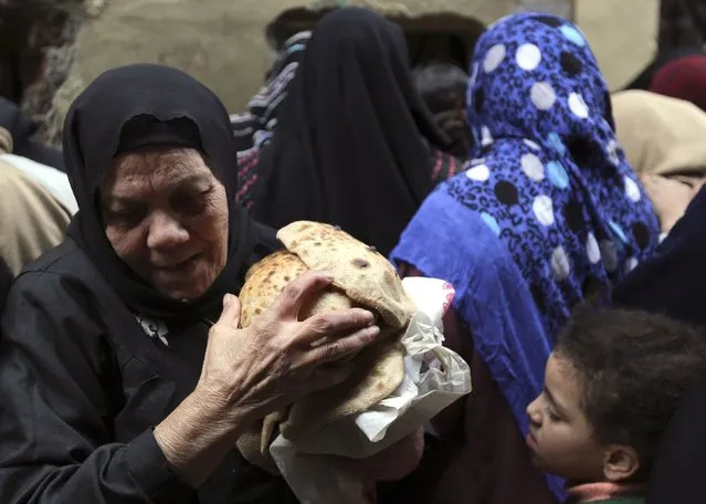 A woman carries bread as she leaves a bakery in Cairo, January 8, 2015. (Photo by Mohamed Abd El Ghany/Reuters)