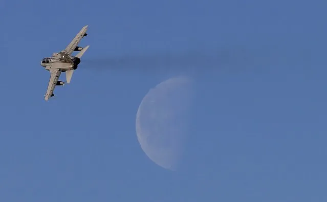 A Royal Air Force Tornado takes off from RAF Lossiemouth with the moon seen in the background, in Scotland, December 2, 2015. (Photo by Russell Cheyne/Reuters)