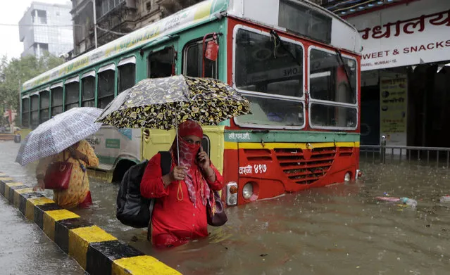 Commuters wade through a water logged street during heavy rain in Mumbai, India, Tuesday, August 4, 2020. India's monsoon season runs from June to September. (Photo by Rajanish Kakade/AP Photo)