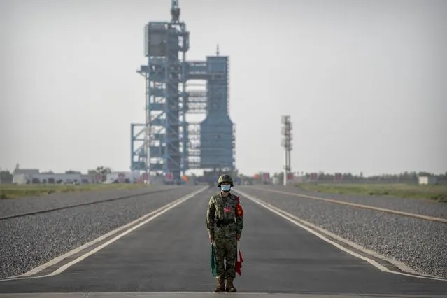 A security officer stands guard before the liftoff of the Shenzhou-16 spaceship at the Jiuquan Satellite Launch Center in northwestern China, Tuesday, May 30, 2023. (Photo by Mark Schiefelbein/AP Photo)