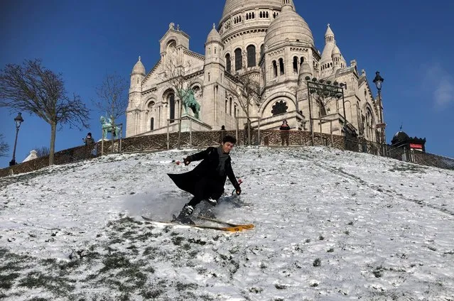 Skier Nathan practices ski down the Montmartre hill near the Sacre Coeur Basilica in Paris as winter weather with snow and cold temperatures hits a large northern part of the country, France, February 10, 2021. (Photo by Antony Paone/Reuters)