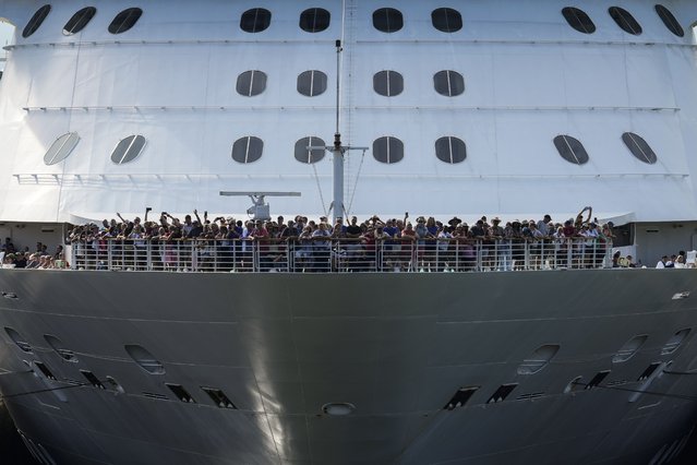 Passengers stand on the forward of the Brilliance of the Seas cruise ship as the vessel approaches the gates of Miraflores Locks to become the first cruiser of the season to pass through the Panama Canal in Panama City, on Monday, October 7, 2024. (Photo by Matias Delacroix/AP Photo)