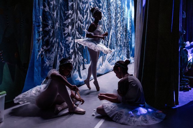Company members of the Dance Centre Kenya (DCK) warm up and prepare their ballet shoes backstage ahead of their performance in The Nutcracker at the Kenya National Theatre in Nairobi on December 7, 2024. The Nutcracker is a beloved Christmas ballet, first performed in 1892, with music by Pyotr Ilyich Tchaikovsky. Known for its enchanting score and festive themes, it has become a holiday tradition worldwide. (Photo by Luis Tato/AFP Photo)