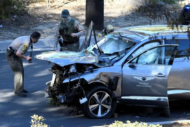 Los Angeles County Sheriff's Deputies inspect the vehicle of golfer Tiger Woods, who was rushed to hospital with severe leg injuries suffered when his car veered off a road and rolled down a steep hillside in Los Angeles, California, February 23, 2021. (Photo by Gene Blevins/Reuters)