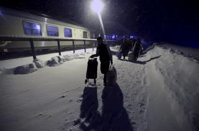 Refugees disembark and make their way to a camp at a hotel touted as the world's most northerly ski resort in Riksgransen, Sweden, December 15, 2015. (Photo by Ints Kalnins/Reuters)