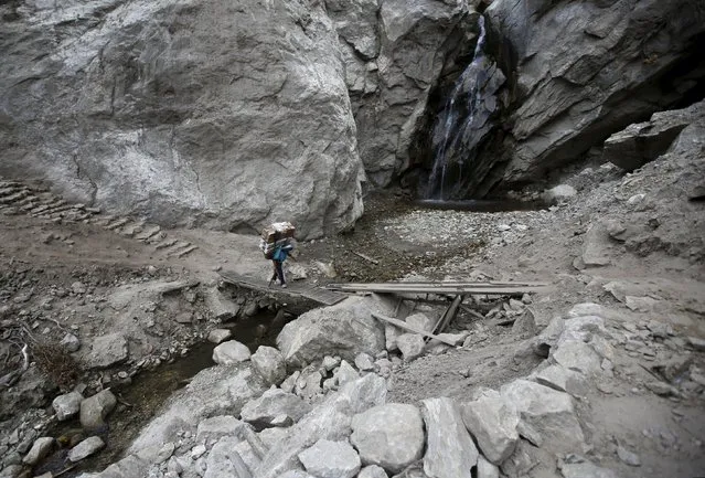 A porter carrying goods walks along the landslide affected area that occurred during the earthquake earlier this year in Solukhumbu district, also known as the Everest region, in this picture taken November 28, 2015. (Photo by Navesh Chitrakar/Reuters)