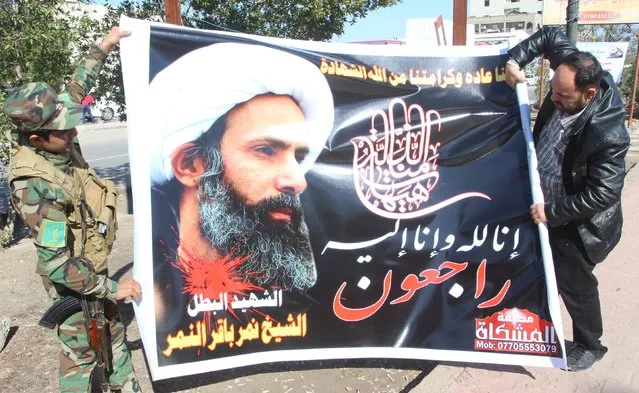Iraqi men hold a banner of Shi'ite cleric Nimr al-Nimr, as they prepare to hang it in a street in Basra, southeast of Baghdad, January 3, 2016. Banner reads, "We belong to Allah and to Him shall we return". (Photo by Essam Al-Sudani/Reuters)