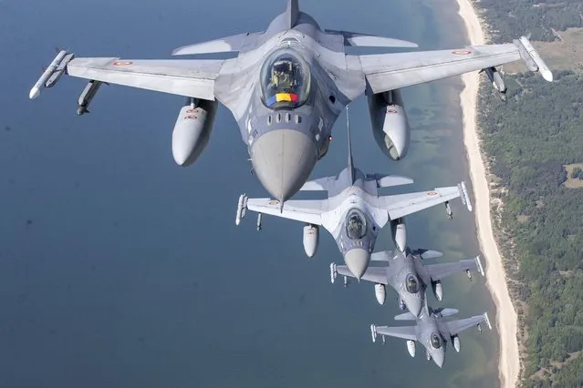 A Romanian Air Force F- 16s military fighter jet, in front, and a Portuguese Air Force F- 16s military fighter jets participating in NATO's Baltic Air Policing Mission operate over the Baltic Sea, Lithuanian airspace, Monday, May 22, 2023. (Photo by Mindaugas Kulbis/AP Photo)