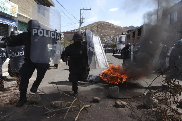 Riot policemen charge at squatters, who were throwing rocks at them, during an eviction at a squatter settlement in Morelia February 12, 2015. (Photo by Alan Ortega/Reuters)