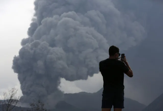 A tourist takes a photo as Mount Bromo volcano erupts in Ngadisari, Probolinggo, East Java, Indonesia January 5, 2016. (Photo by Darren Whiteside/Reuters)