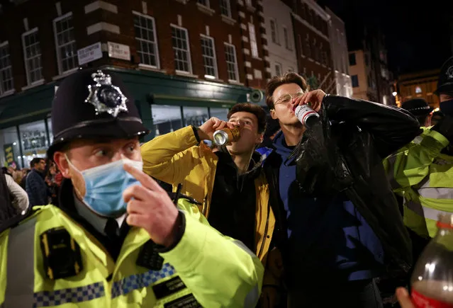 Police gesture next to people partying along a street in Soho, as the coronavirus disease (COVID-19) restrictions ease in London, Britain, April 17, 2021. (Photo by Henry Nicholls/Reuters)