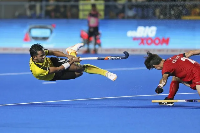Malaysia's Faizal Saari is in the air as he hits the ball past Korea's Hyeongjin Kim during the first semifinal men's Asian Champions Trophy hockey match between Malaysia and Korea in Chennai, India, Friday, August 11, 2023. (Photo by R. Parthibhan/AP Photo)