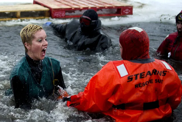 Hayden Gosen, left, Jacqueline Reimers, middle, and Allyson Reimers, right, from team Reimers jump into the pond at the William H. Haithco Recreation Area during the Michigan Law Enforcement Polar Plunge for Special Olympics, Saturday, February 21, 2015, in Saginaw Township, Mich. There were about 145 participants and $28,000 raised at the event. (Photo by Andrew Whitaker/AP Photo/The Saginaw News)
