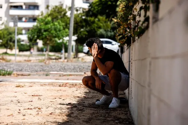 A man takes cover as a siren warning of incoming rockets launched from the Gaza Strip towards Israel sounds, in Ashkelon, Israel on May 20, 2021. (Photo by Amir Cohen/Reuters)