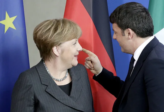 German Chancellor Angela Merkel, left, and Prime Minister of Italy Matteo Renzi, right, talk after a joint press conference as part of a meeting at the chancellery in Berlin, Germany, Friday, January 29, 2016. (Photo by Michael Sohn/AP Photo)