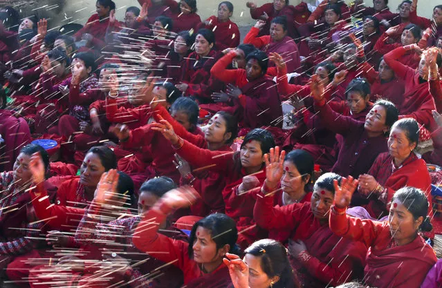 Nepalese Hindu women wearing red attire worship during the Madhav Narayan Festival in Sankhu near Kathmandu, Nepal, on February 1, 2016. The festival marks a month long devoted to religious fasting, holy bathing and the study of the Swasthani book, a chapter or story of which is read each evening by priests or householders to the gathered family. More than 220 married and unmarried women including dozens of male devotees started their month-long fast for better life and peace at temple premises. (Photo by Narendra Shrestha/EPA)