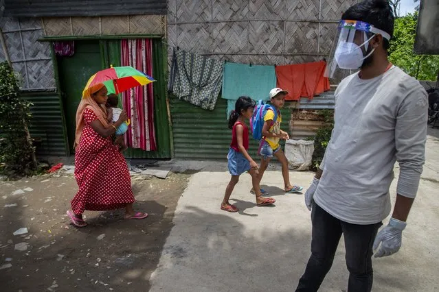 A health worker arrives in a residential neighborhood to collect swab samples from residents to test for COVID-19 during a door-to-door testing drive in Gauhati, India, Friday, July 9, 2021. (Photo by Anupam Nath/AP Photo)