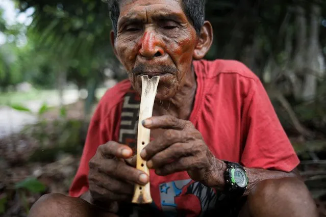 An Indigenous man plays music on a settlement close to the Pira Parana River, Vaupes province, Colombia, on November 10, 2023. (Photo by Juan Pablo Pino/AFP Photo)
