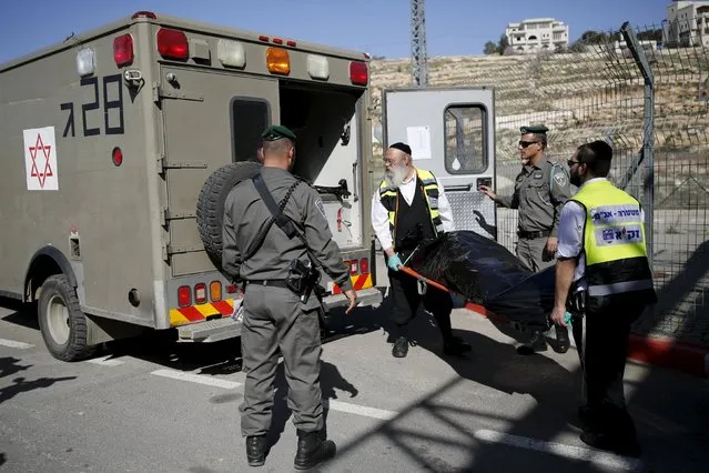 Israeli emergency service personnel evacuate the body of a Palestinian who was killed by Israeli troops after, police said, he tried to stab an Israeli paramilitary policeman at a checkpoint in the West Bank, near Jerusalem February 14, 2016. (Photo by Amir Cohen/Reuters)