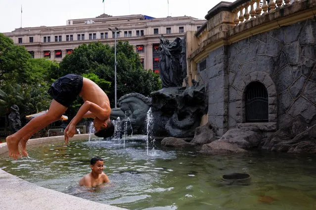 Boys cool off in a fountain, during a heatwave in the Anhangabau Valley, in the centre of Sao Paulo, Brazil on November 16, 2023. (Photo by Amanda Perobelli/Reuters)
