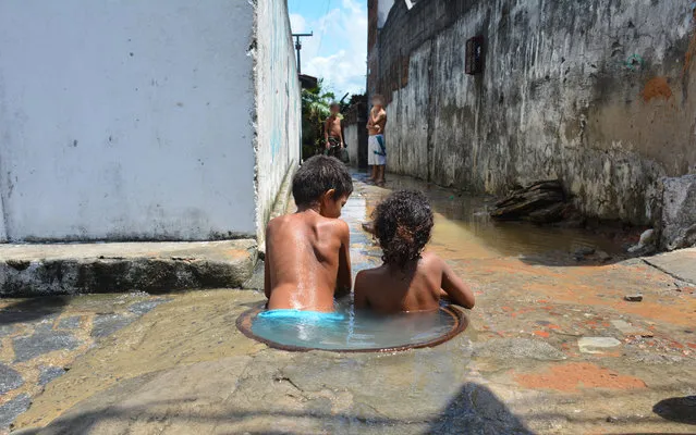 Children are seen playing in a culvert in May Thirteen district of João Pessoa, Paraíba in Brazil on April 10, 2015. (Photo by Walter Paparazzo/G1)