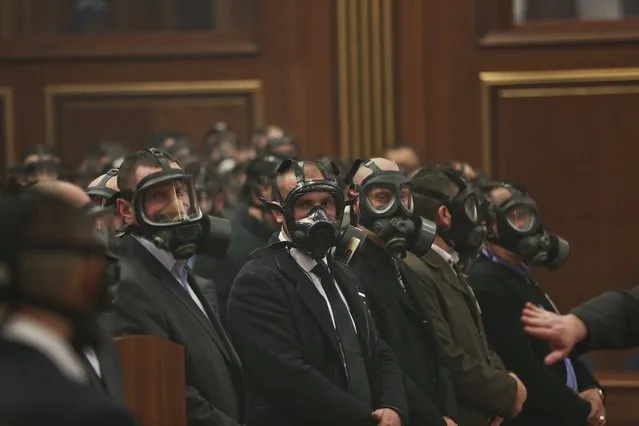 Security forces wear gas masks at the Kosovo assembly, after opposition lawmakers released tear gas canisters disrupting a parliamentary session in Kosovo's capital Pristina on Friday February 26, 2016. Kosovo opposition members have released tear gas inside Parliament as the lawmakers were readying to vote on wether to elect Hashim Thaci, foreign minister and former guerrilla leader, as the next president. (Photo by Visar Kryeziu/AP Photo)