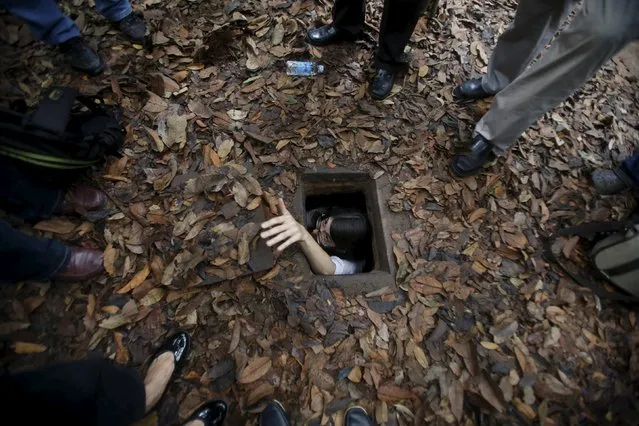 A French journalist tries to disappear into the Cu Chi tunnel network through a hole camouflaged on the jungle floor during a guided tour some 70 km (44 miles) from Ho Chi Minh City (formerly Saigon City), Vietnam,  April 28, 2015. The 200 km (124 miles) underground tunnel network includes sections for living, dining, meeting and fighting and was used during the resistance against the U.S. during the Vietnam War. (Photo by Reuters/Kham)