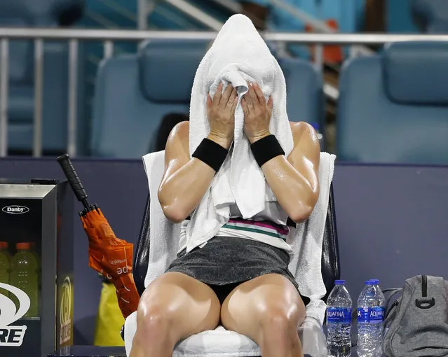 Simona Halep, of Romania, sits with a towel on her face during her match with Karolina Pliskova, of the Czech Republic, during a semifinal in the Miami Open tennis tournament Thursday, March 28, 2019, in Miami Gardens, Fla. (Photo by Joe Skipper/AP Photo)
