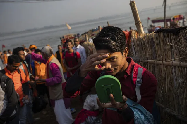 In this Sunday, November 25, 2018 photo, a Hindu hardline supporter applies saffron to his forehead in Ayodhya, Uttar Pradesh, India. As with similar movements across the world, Hindu nationalism, once fringe, has now taken a central place in India’s politics. (Photo by Bernat Armangue/AP Photo)