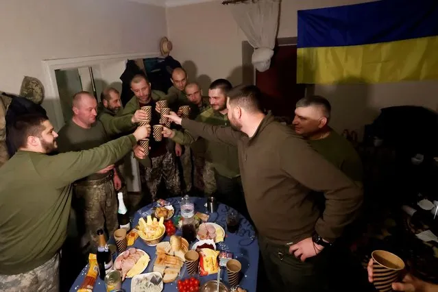 Ukrainian soldiers share a toast to celebrate New Years Eve, in a military rest house, as Russia's attack on Ukraine continues, in region of Donetsk, Ukraine on December 31, 2022. (Photo by Clodagh Kilcoyne/Reuters)