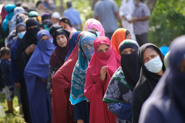 Voters wait in a queue outside a polling centre in Srinagar, Munshiganj district, Bangladesh, Thursday, November 11, 2021. Bangladesh is holding village council elections certain to further consolidate the ruling party’s power but that have raised concerns about the state of democracy. The largest opposition party is boycotting the vote after the last two national elections were tainted by misconduct allegations. (Photo by Mahmud Hossain Opu/AP Photo)