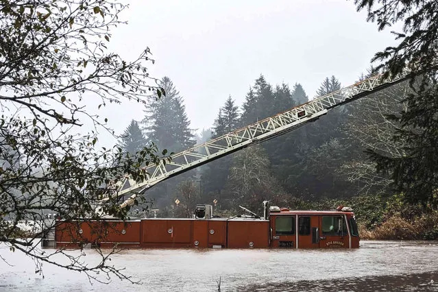 In this photo provided by the Lincoln County Sheriff's Department, a fire engine is surrounded by rising waters in Otis, Ore., Friday, November 12, 2021. The U.S. Coast Guard has used two helicopters to rescue about 50 people from rising waters at an RV park on the Oregon Coast Friday as heavy rains in the Pacific Northwest prompted warnings of floods and landslides. (Photo by Sgt. Jack Dunteman/Lincoln County Sheriff's Department via AP Photo)