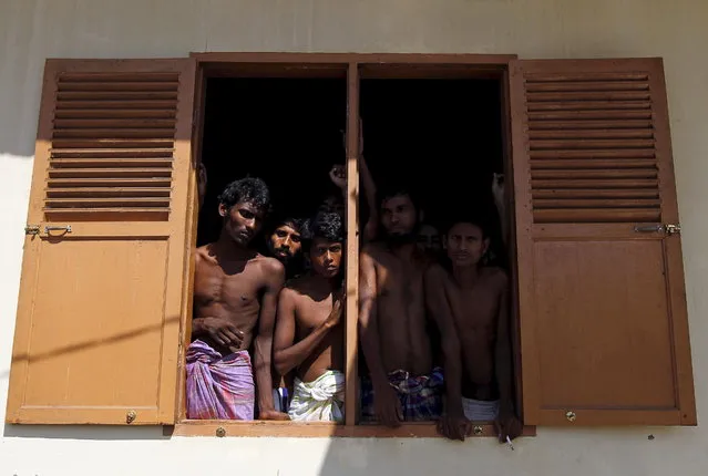 Migrants believed to be Rohingya look out from the window of a shelter after being rescued from boats, in Lhoksukon, Indonesia's Aceh Province May 11, 2015. (Photo by Roni Bintang/Reuters)