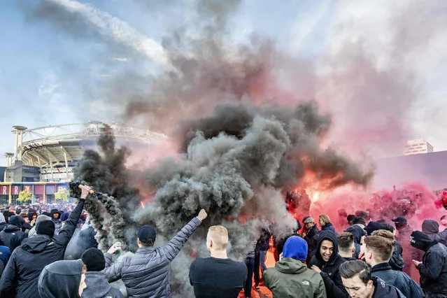 Ajax fans wave flares outside the Johan Cruyff Arena prior to the UEFA Champions League semi-final second leg football match between Ajax Amsterdam and Tottenham Hotspur, in Amsterdam, on May 8, 2019. (Photo by Niels Wenstedt/ANP/AFP Photo)