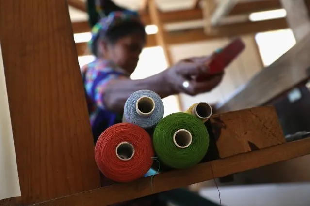 Indigenous Mayan weaver Delfina Perez, who's husband has worked in the U.S. as an immigrant for 20 years, works on a foot loom at the Grupo Cajola weaving cooperative on February 11, 2017 in Cajola, Guatemala. (Photo by John Moore/Getty Images)