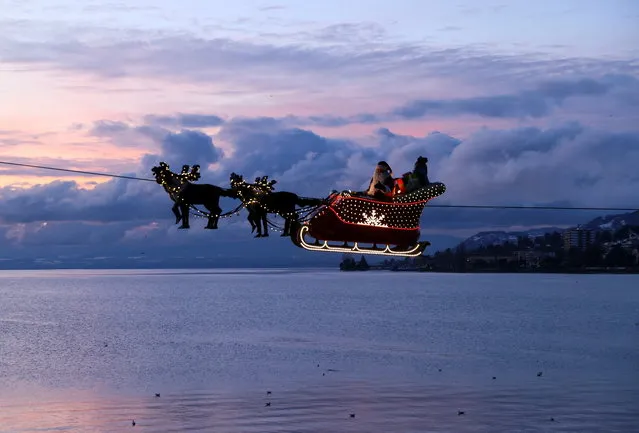 Saint Nicholas and his reindeers fly above Lake Leman at the Christmas Market, amid the coronavirus disease (COVID-19) pandemic, in Montreux, Switzerland on December 6, 2021. (Photo by Denis Balibouse/Reuters)