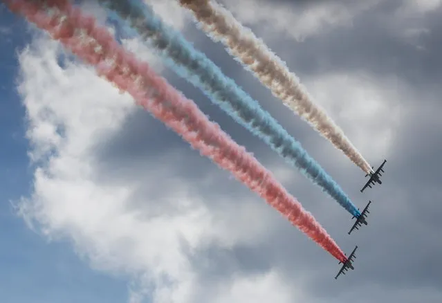 Su-25 jet fighters release smoke in the colours of the Russian state flag during the opening ceremony of the International military-technical forum ARMY-2019 at Patriot Congress and Exhibition Centre in Moscow Region, Russia on June 25, 2019. (Photo by Maxim Shemetov/Reuters)