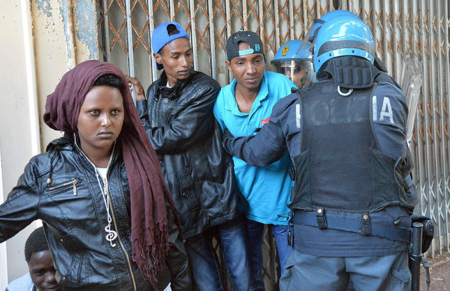 Italian police officers drag away migrants in Ventimiglia, at the Italian-French border Tuesday, June 16, 2015. Police at Italy's Mediterranean border with France have forcibly removed some of the African migrants who have been camping out for days in hopes of continuing their journeys farther north. The migrants, mostly from Sudan and Eritrea, have been camped out for five days after French border police refused to let them cross. (Luca Zennaro/ANSA via AP)