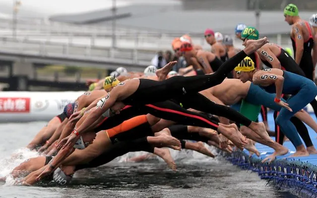 Swimmers dive into the water at the start of the women's 10km open water swim at the World Swimming Championships in Yeosu, South Korea, Sunday, July 14, 2019. (Photo by Mark Schiefelbein/AP Photo)