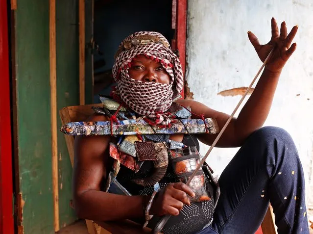 A masked female member of the anti-balaka, a Christian militia, holds a machete as she sits in a village of Zawa April 8, 2014. (Photo by Goran Tomasevic/Reuters)