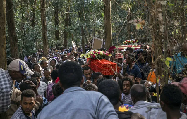 The coffin of one of those lost in the collapse of a mountain of trash at a garbage dump arrives for the burial, at the Gebrekristos church in Addis Ababa, Ethiopia Monday, March 13, 2017. (Photo by Mulugeta Ayene/AP Photo)