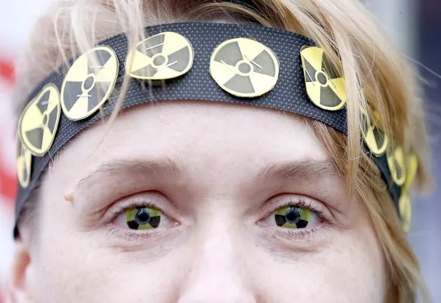 A protester wears eye-lenses with radioactive signs, as she participates in a rally to mark the 30th anniversary of the Chernobyl nuclear disaster in Minsk, Belarus, 26 April 2016. The 30th anniversary of the Ukrainian, Chernobyl nuclear disaster is marked on 26 April 2016. (Photo by Tatyana Zenkovich/EPA)
