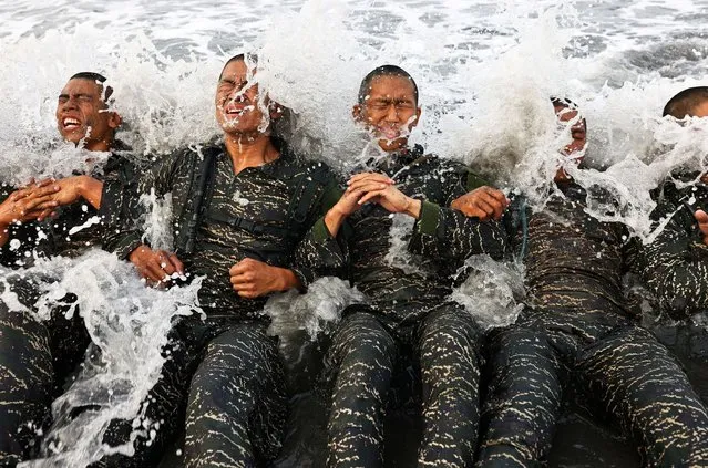 ARP trainees battle the waves while completing training exercises during the last week of a ten week program to become members of the Taiwan navy's elite Amphibious Reconnaissance and Patrol unit, at Zuoying navy base, Kaohsiung, southern Taiwan, December 18, 2021. The trainees have to endure everything from long marches to hours in the water, with constant screaming at by their instructors. Of the group of 31 who started the program, only 15 finished. (Photo by Ann Wang/Reuters)
