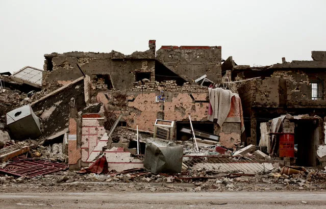 A family house lies in ruins in the Iraqi city of Ramadi on March 20, 2016, weeks after the city was retaken from the Islamic State group. Entire city blocks were leveled by fighting, airstrikes and by the militants themselves, deliberately blowing up buildings as they fled. For many residents, their homes represented their entire life's savings, and few have the means to rebuild, presenting a massive reconstruction task for an overburdened Iraqi government. (Photo by Maya Alleruzzo/AP Photo)